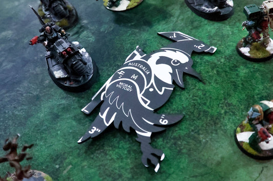 Miniature figures on a green game board with a logo in the center.